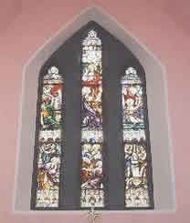 Stained glass windows behind the altar in Crecora church