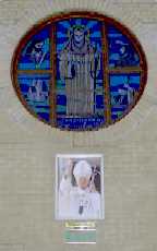 Stained glass window of St Brigid and picture of Pope John Paul II