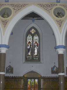 Stained Glass Window of St Catherine and St Dominic.  Fr Buckley's paintings can be seen in the top corners of the photograph.